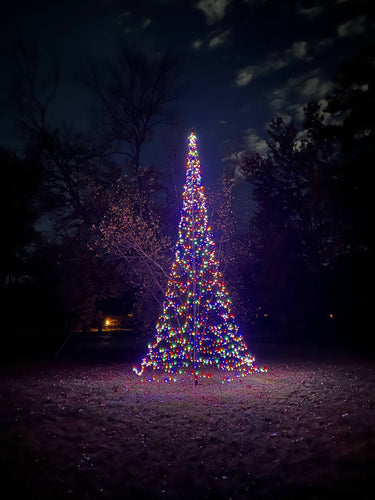 Color-changing LED Christmas tree for flagpole, illuminated with vibrant lights, displayed in a nighttime setting.